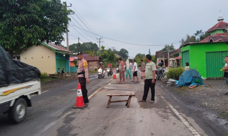 Bhabinkamtibmas Polsek Wonosobo Bripka Mujiono Bersama Warga saat Gotong Royong Perbaiki Jalan Berlubang di Pekon Negeri Agung, Kecamatan Bandar Negeri Semoung. Foto : Asrul Ariski/Media Prioritastv.com.
