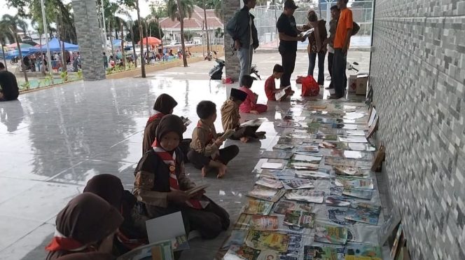 
 Antusiasme anak-anak membaca buku di lapak baca Komunitas Tanggamus Membaca di Taman Soekarno, Kota Agung, Senin 10 Maret 2025 | Herdi/Media Prioritastv.com.