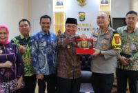 Bupati Tanggamus Moh Saleh Asnawi saat menyerahkan buku jalan lurus dalam kunjungan ke Polres Tanggamus, Kamis 13 Maret 2025 | Dok. Istimewa.