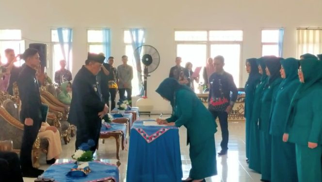 
 Ketua TP PKK Tanggamus, Hj. Siti Mahmudah saat menandatangani berita acara pengukuhan di hadapan Bupati Moh. Saleh Asnawi, Jumat 14 Maret 2025 | Dok. Kominfo Tanggamus.