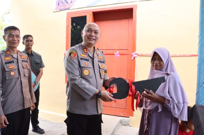 
 Kapolres Tanggamus AKBP Rivanda secara simbolis menyerahkan kunci rumah kepada Surtini yang rumahnya telah dibedah, Selasa 18 Maret 2025 | Herdi/Media Prioritastv.com.