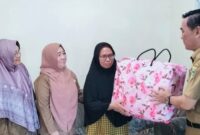 Kepala SMPN 1 Kota Agung, Jaya Mangku Desa saat menyerahkan Cinderamata kepada Sugiarsih Guru SMPN 1 Kota Agung yang telah purnatugas, Selasa 22 April 2025 | Herdi/Media Prioritastv.com.