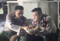 Potres Bripka Baim dan Bripka Mulya berbagi nasi bungkus saat hujan deras di dermaga Bakauheni, Lampung Selatan, Rabu 2 April 2025 | Dok. Istimewa.