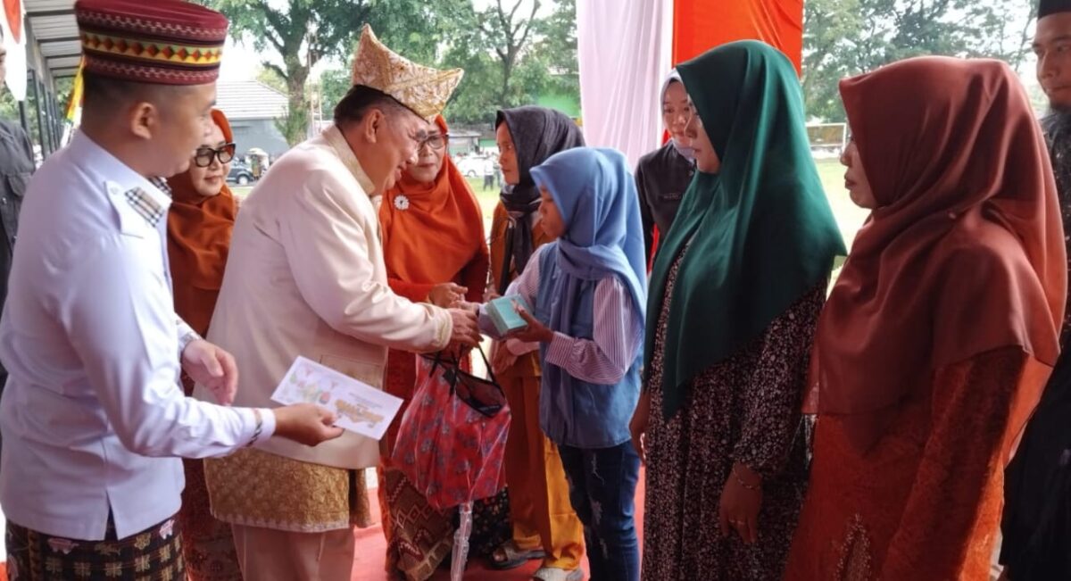Bupati Tanggamus Moh Saleh Asnawi didampingi Ketua LKS Alamanda Tanggamus saat menyerahkan bantuan sosial usai upacara Hari Kartini di Lapangan Merdeka, Kota Agung, Senin 21 April 2025 | Herdi/Media Prioritastv.com.