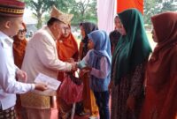 Bupati Tanggamus Moh Saleh Asnawi didampingi Ketua LKS Alamanda Tanggamus saat menyerahkan bantuan sosial usai upacara Hari Kartini di Lapangan Merdeka, Kota Agung, Senin 21 April 2025 | Herdi/Media Prioritastv.com.