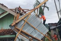 Petugas BPBD Tanggamus saat bersama warga mengevakuasi atas rumah yang terdampak puting beliung di Pekon Teratas, Kota Agung, Jumat 9 Mei 2025 | Herdi/Media Prioritastv.com.
