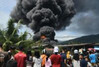 Warga saat menyaksikan kebakaran pabrik karet milik PT Teluk Luas Kecamatan Lubuk Begalung, Padang, Sumatera Barat, Minggu 18 Mei 2025, pukul 13.00 WIB.
