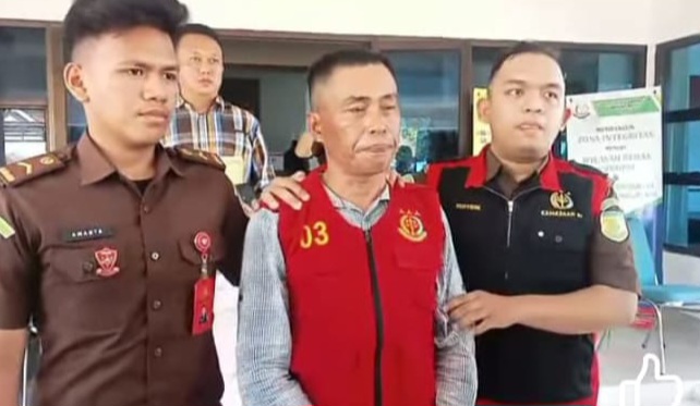 Yuzid, mantan Peratin (Kepala Desa) Pekon Tanjung Kemala, Kecamatan Bangkunat, Kabupaten Pesisir Barat, Lampung saat digiring tim Kejari Pesisir Barat, Senin 19 Mei 2025 | Suroso/Media Prioritastv.com.