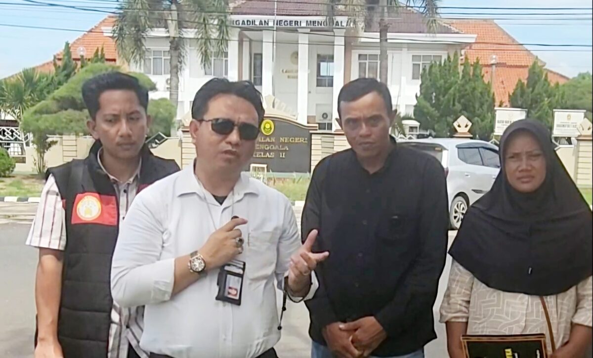 Kuasa hukum Gindha Ansori Wayka (berkemeja putih, memegang mikrofon) bersama pasangan Pingi Sudarsono dan Patonah (kanan) memberikan keterangan pers di depan Pengadilan Negeri Menggala, Kabupaten Tulang Bawang, Lampung, usai pencabutan gugatan oleh pihak BRI terkait sengketa rumah yang mereka alami, Kamis (22/5/2025).
