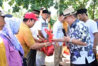Bupati Tanggamus Moh. Saleh Asnwi saat membagikan daging kurban Partai Gerindra Dapil V Tanggamus, Minggu 8 Juni 2025 |