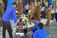 Tim Damkar saat mengeluarkan ular dari dalam body motor anak PKL di Kantor Diskominfo Pringsewu, Senin 3 Juni 2025.