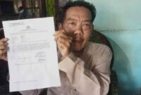 Dul Pepati, orang tua AB korban pembacokan sadis Kades Batu Badak menunjukkan bukti laporan penganiayaan berat terhadap anaknya ke Polda Lampung, Selasa 8 Juli 2025 |