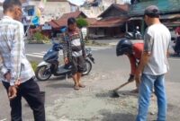 Para pengojek pasar kota agung saat menambal jalan di area sekitar Bank Lampung, Kamis 10 Juli 2025 | Ist.