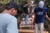 Para pemuda Tanjung Raja, Cukuh Balak, Tanggamus saat memperbaiki jembatan gantung guna kelancaran pelajar sekolah memasuki tahun ajaran baru, Minggu 13 Juli 2025 | Bahyuti/Media Prioritastv.com.