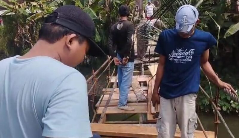 Para pemuda Tanjung Raja, Cukuh Balak, Tanggamus saat memperbaiki jembatan gantung guna kelancaran pelajar sekolah memasuki tahun ajaran baru, Minggu 13 Juli 2025 | Bahyuti/Media Prioritastv.com.