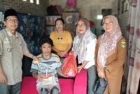 Ketua LKS Alamanda Tanggamus, Roswati Purwantari bersama Kepala Pekon Amin Jasuta saat menyerahkan bantuan kepada Rosidi, Selasa 15 Juli 2025 | Ist.