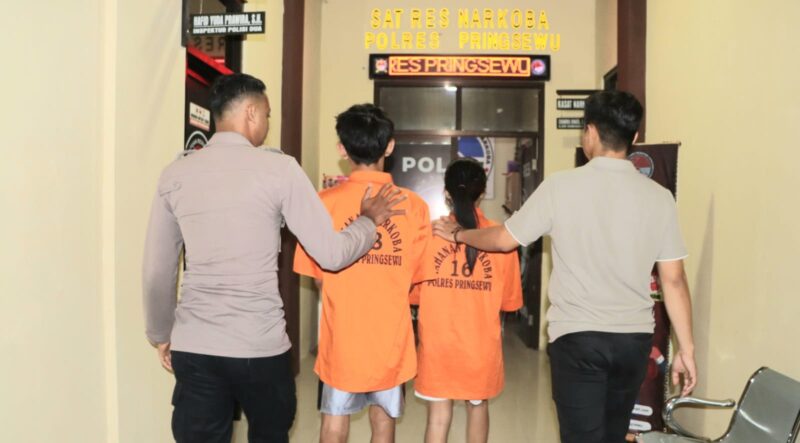 Kedua pasangan kekasih pelaku produksi tembakau sintetis saat akan dijebloskan ke sel tahanan, Jumat 18 Juli 2025 | Dok. Humas Polres Pringsewu.