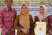 Kakon Tekad Tuti Arifin Bersama Ketua KDMP Ibu Mike saat Foto Bersama Usai Penyerahan Akta Hukum Usaha (AHU) oleh Bupati Tanggamus. Foto : Asrul Ariski. 