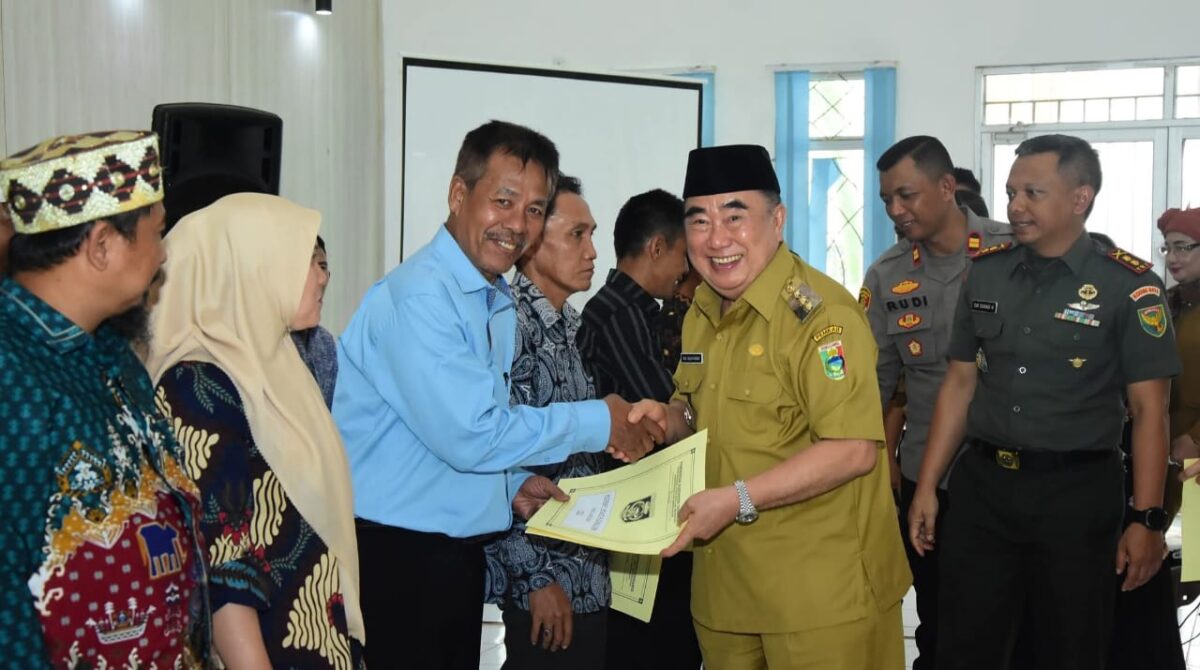 Bupati Tanggamus, Moh. Saleh Asnawi saat menyerahkan Akta Hukum Usaha kepada salah satu perwakilan ketua Kopdes Merah Putih di GFU Islamic Center, Kota Agung, Senin 21 Juli 2025 | Dok. Kominfo Tanggamus.