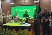 Kajari Tanggamus Adi Fakharuddin saat memberikan tumpeng kepada personil Kejari Tanggamus, Selasa 22 Juli 2025 | Ist.
