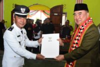 Bupati Tanggamus Moh. Saleh Asnawi saat nenyerahkan keputusan kepada Zuhaidi, sebagai Penjabat (PJ) Kepala Pekon Sukamernah, Kecamatan Gunung Alip, Rabu 23 Juli 2025 | Asrul Ariski/Media Prioritastv.com.