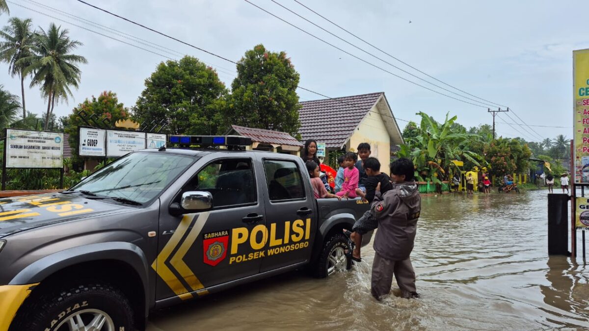 Polisi saat melakukan evakuasi anak-anak yang akan melintasi banjir di Wonosobo Tanggamus, Selasa 29 Juli 2025 | Dok. Humas Polres Tanggamus.