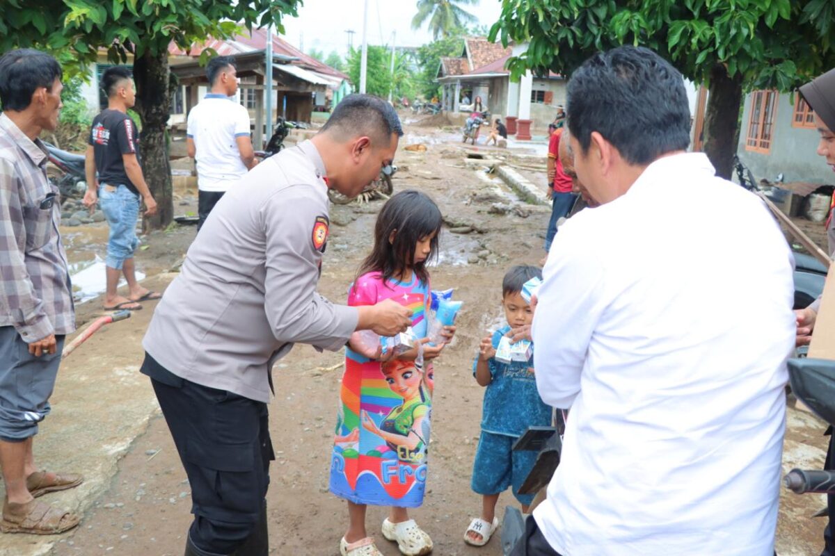 Kapolres Tanggamus AKBP Rahmad Sujatmiko saat memberikan sedikit kebahagiaan kepada anak-anak terdampak banjir di Pekon Banding, BNS, Selasa 29 Juli 2025 |