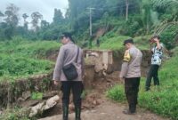 Kapolsek Wonosobo Iptu Tjasudin saat meninjau jembatan ambrol penghubung Pekon Sanggi dan Atar Lebar, Bandar Negeri Semuong, Tanggamus, Kamis 31 Juli 2025 | Dok. Polres Tanggamus.