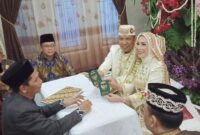 Ketua DPRD Kota Metro, Ria Hartini dan AKBP M. Yamil saat menunjukan buku nikah mereka, Minggu 27 Juli 2025 | Raditya/Media Prioritastv.com.