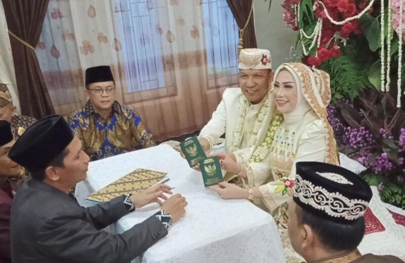 Ketua DPRD Kota Metro, Ria Hartini dan AKBP M. Yamil saat menunjukan buku nikah mereka, Minggu 27 Juli 2025 | Raditya/Media Prioritastv.com.