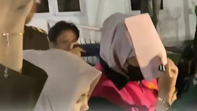 Tersangka Cindy Armila, pegawai Bank BRI Kantor Cabang Pringsewu (menutup wajah) saat digiring Kejati Lampung ke mobil tahanan, Senin 21 Juli 2025, malam | Dok. Kejati Lampung.