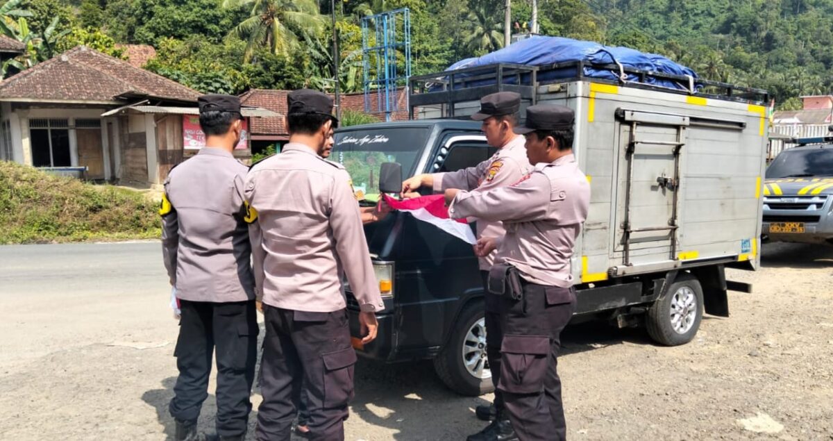 Anggota Polsek Semaka saat memasang bendera di kendaraan yang melintasi Jalinbar Tanggamus, Jumat 8 Agustus 2025 | Dok. Humas Polres Tanggamus.