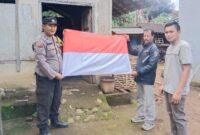 Aiptu Rasdin Bhabinkamtibmas Polsek Pulau Panggung Polres Tanggamus saat Memberikan Bendera Merah Putih kepada Masyarakat Pekon Ngarip.