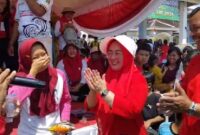 Kakon Tekad Tuti Aripin didampingi Ketua Granat Tanggamus Agus Ciek Yamin, S.E, saat menyerahkan hadiah utama kepada salah satu pemenang usia jalan sehat, Minggu 24 Agustus 2025 | Herdi/Media Prioritastv.com.