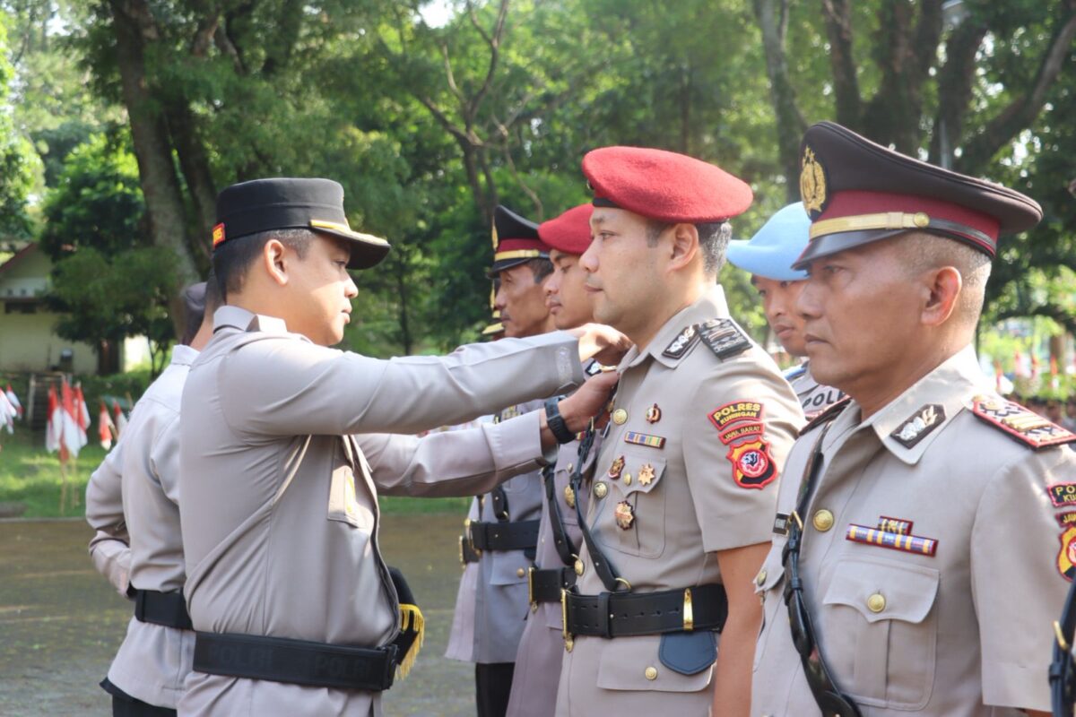 Kapolres Kuningan AKBP M. Ali Akbar menyematkan tanda jabatan kepada perwira yang menjalani serah terima jabatan di Halaman Gedung Naskah Linggarjati, Senin (25/8/2025).