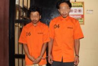 Kedua tersangka saat akan dijebloskan ke sel tahanan, Selasa 26 Agustus 2025 | Dok. Humas Polres Pringsewu.