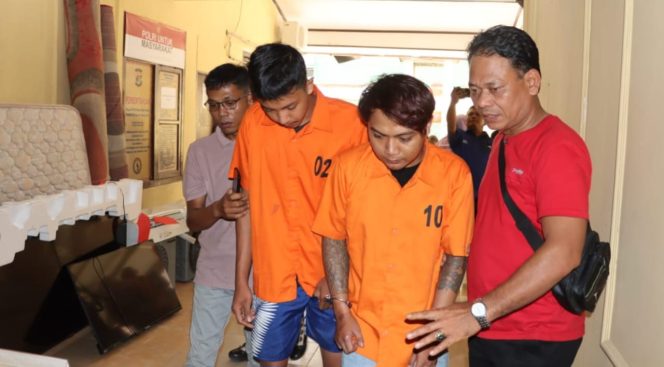 
					Kedua tersangka saat digiring menuju sel tahanan Polres Pringsewu, Jumat 26 September 2025 | Sameul/Media Prioritastv.com.