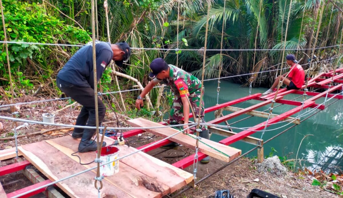 Sertu Imamudin saar berjibaku bekerja bersama tim ahli jembatan di Sungai Sindaur Balak, Tampang Muda, Pematang Sawa, Tanggamus, Jumat 26 September 2025 | Ist.