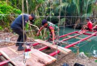 Sertu Imamudin saar berjibaku bekerja bersama tim ahli jembatan di Sungai Sindaur Balak, Tampang Muda, Pematang Sawa, Tanggamus, Jumat 26 September 2025 | Ist.