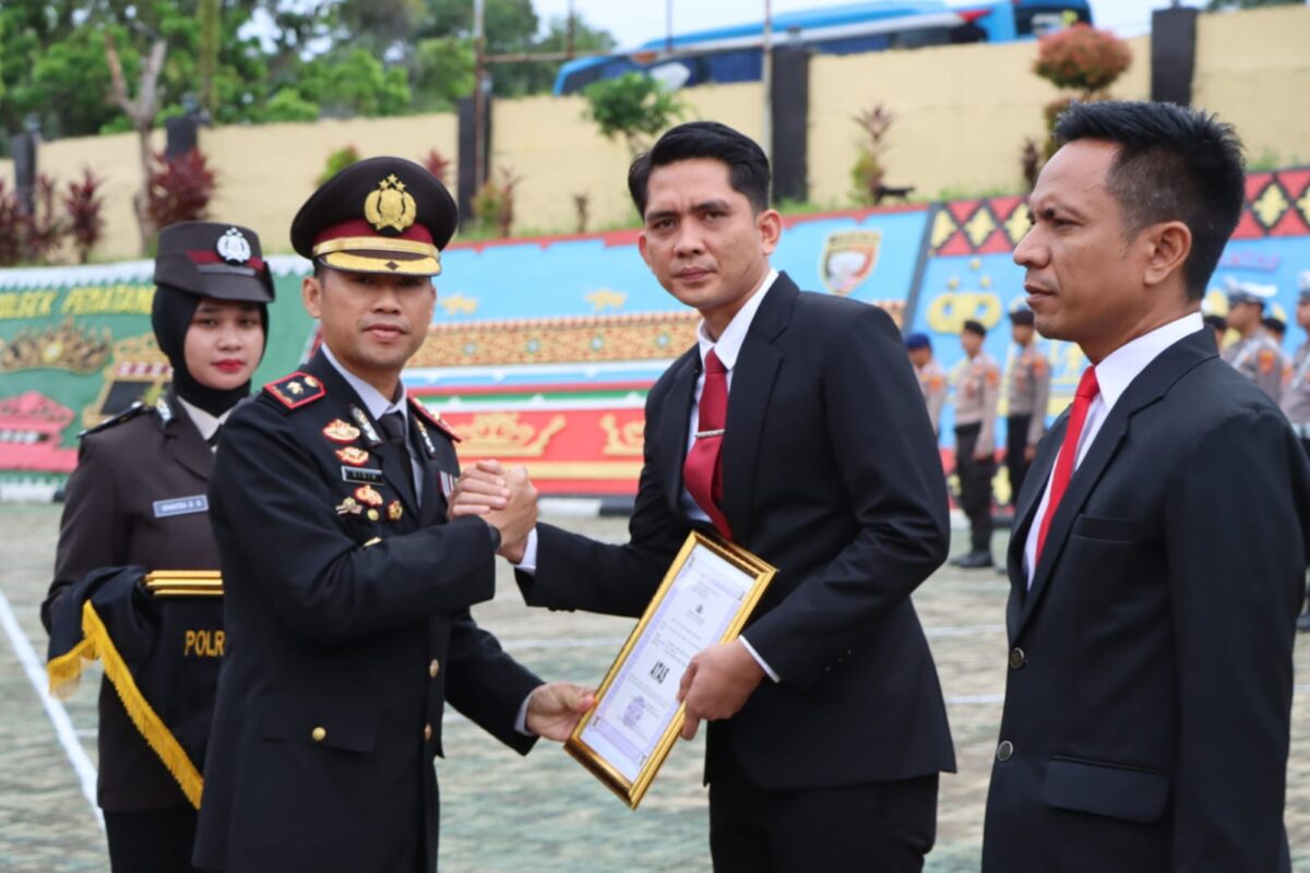 Wakapolres Tanggamus Kompol Gigih Andri Putranto saat menyerahkan piagam penghargaan kepada Kasat Reskrim di Lapangan Mapolres setempat, Senin 10 November 2025 | Dok. Humas Polres Tanggamus.