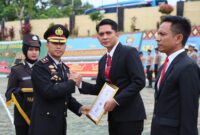 Wakapolres Tanggamus Kompol Gigih Andri Putranto saat menyerahkan piagam penghargaan kepada Kasat Reskrim di Lapangan Mapolres setempat, Senin 10 November 2025 | Dok. Humas Polres Tanggamus.