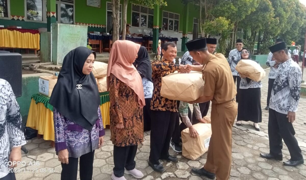 Sekcam Kota Agung Timur Efendi di saksikan kepala SPLP Kotim Basuki saat memberikan cindramata kepada pars guru yang memasuki masa Purna Bakti di SD Negeri 1 Tanjung Anom Kota Agung Timur setelah upacara HUT ke 80 PGRI dan HGN, Selasa (25/11/2025) | Herdi/Media Prioritastv.com.