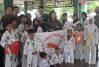 Kajari Pringsewu Evi Hasibuan berfoto bersama para atlet Taekwondo Macan Sewu Student Club usai penyerahan bantuan peralatan latihan di Aula Pendopo Pringsewu, Kamis sore.(Foto: Prioritas tv.com/istimewa)