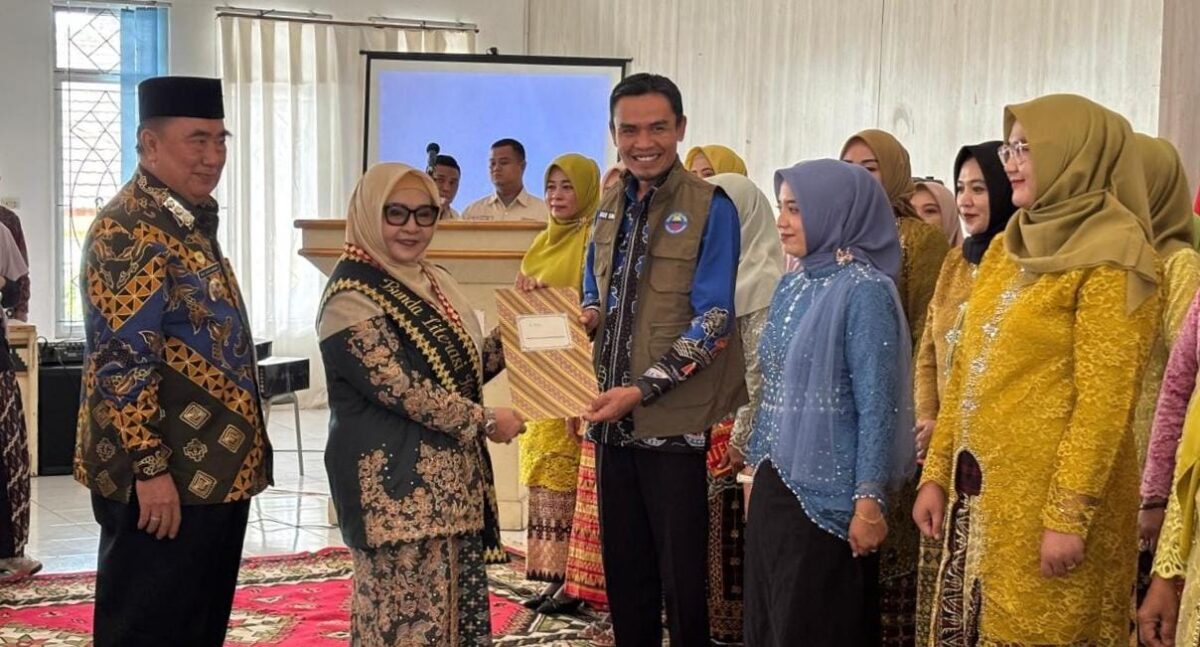 Bunda Literasi Tanggamus Hj. Siti Mahmudah saat menyerahkan surat pengukuhan Penggerak dan Duta Literasi dan Duta Baca Kabupaten kepada Wabup Agus Suranto di GSG Islamic Center Kota Agung, Kamis 4 Desember 2025 | Herdi/Media Prioritastv.com.