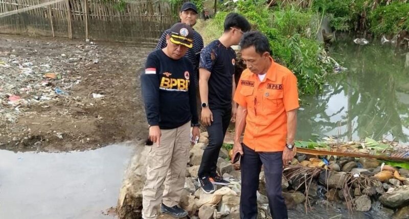 Kabid Pencegahan dan Kesiapsiagaan BPBD Tanggamus, Henderman saat melaksanakan assemen penyebab banjir kapuran di aliran kali bego, Pasar Madang, Kota Agung, Kamis 4 Desember 2025 | Dok. BPBD Tanggamus.