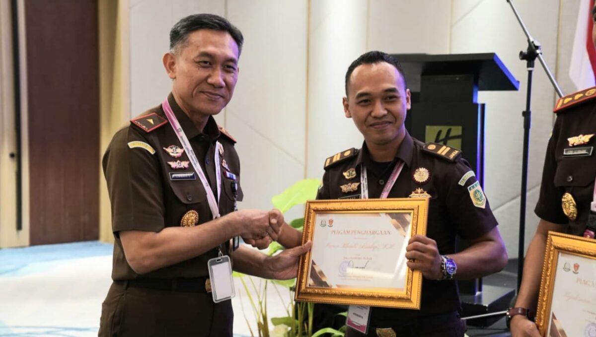 Kepala Kejaksaan Tinggi Lampung, Danang Suryo Wibowo saat menyerahkan penghargaan kepada Irvan Khasbi Assidiqi yang dinobatkan sebagai Jaksa Fasilitator Terbaik se-Provinsi Lampung.