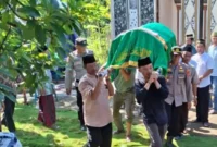 Kapolsek Kota Agung AKP Feriyantoni saat ikut serta memanggul jenazah korban menuju pemakaman, Kamis 26 Desember 2025 | Dok. Humas Polres Tanggamus.