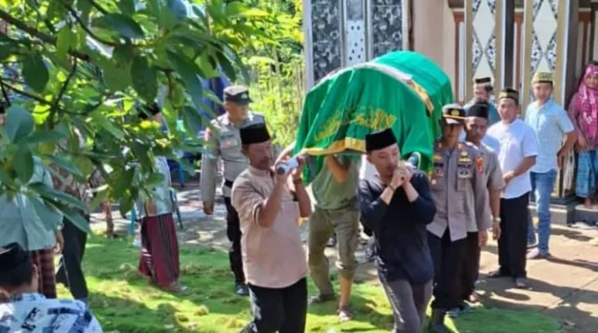 Kapolsek Kota Agung AKP Feriyantoni saat ikut serta memanggul jenazah korban menuju pemakaman, Kamis 26 Desember 2025 | Dok. Humas Polres Tanggamus.