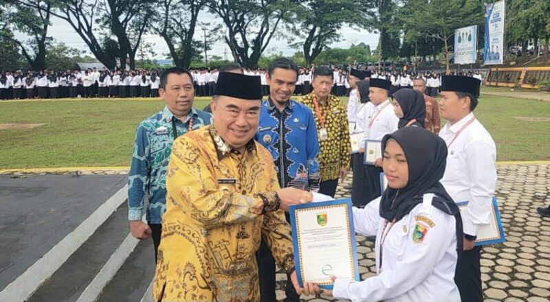 Bupati Tanggamus H. Moh. Saleh Asnawi saat menyerahkan SK PPPK Paruh Waktu kepada perwakilan pegawai di Lapangan Pemkab setempat, Jumat 2 Januari 2025 | Herdi/Media Prioritastv.com.