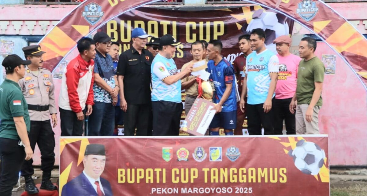 Bupati Tanggamus H. Moh. Saleh Asnawi saat menyerahkan hadiah kepada tim Tirtatama Peko Sumberejo, juara pertama open turnamen sepak bola Bupati Tanggamus Cup di Lapangan Margoyoso, Sumberejo, Minggu 11 Januari 2025 | Herdi/Media Prioritastv.com.